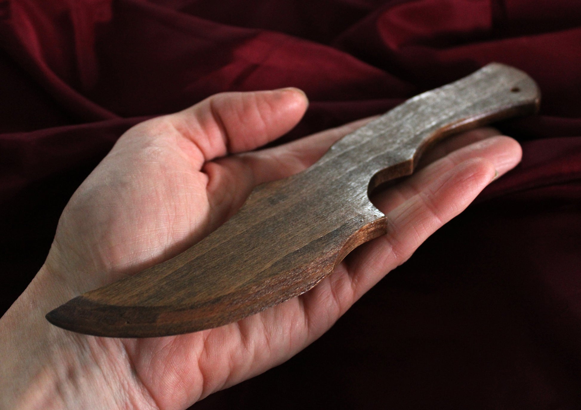 couteau bdsm stylisé en bois tenu en main