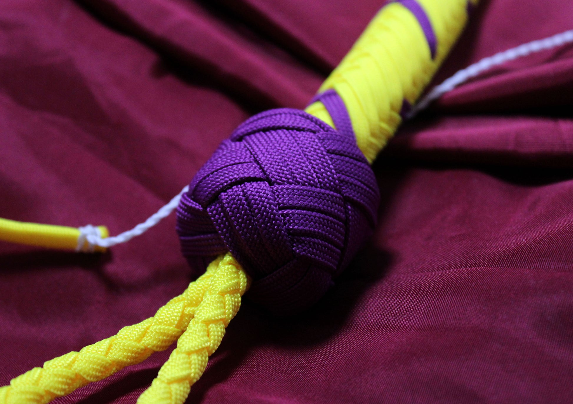 détail du knot violet, tranchant avec le fond jaune du reste du fouet
